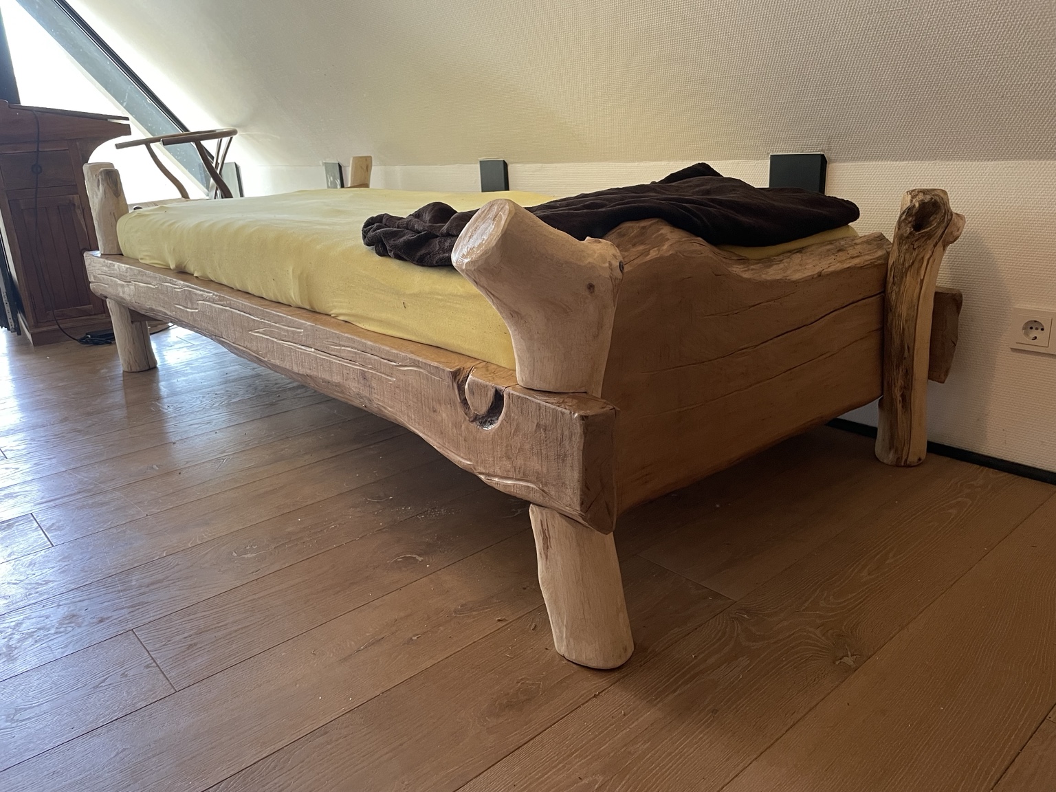 Rustikales Holzbett mit natürlichen Formen.